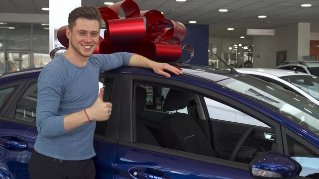 Happy male customer gives a thumbs up next to a stylish car