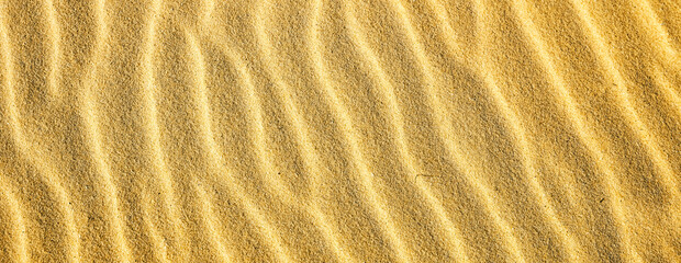 Sand surface with ripple pattern close view ideal for outdoor, eco and relaxation themes. Natural background for calm and peaceful projects