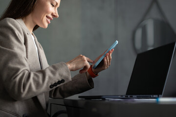 Woman with smartphone at her desk. Office workplace