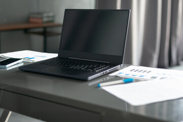 Laptop documents papers on desk workspace in office or at home
