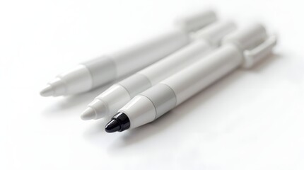 Three sleek, modern writing instruments in black, white, and gray, arranged artistically on a soft white background.
