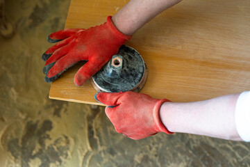 sanding a wooden surface with a sander