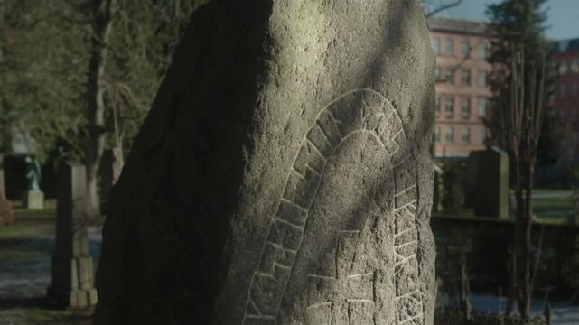 Rune stone in an old Danish cemetery. 
Close-up of the runic writing, with a movement from the top to the bottom.