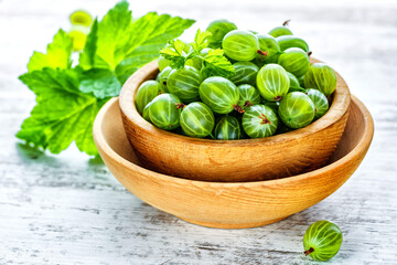 Green Organic Berries Gooseberries.Green gooseberries in a wooden bowl.Gooseberries on the wooden table. Harvest concept. Vegetarian food.