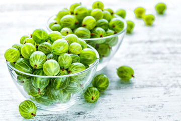 Green Organic Berries Gooseberries.Ripe gooseberry in a glass plate.Gooseberries on the wooden table. Harvest concept. Vegetarian food.