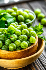 Green Organic Berries Gooseberries.Green gooseberries in a wooden bowl.Gooseberries on the wooden table. Harvest concept. Vegetarian food.