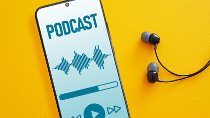 Smartphone with podcast screen and headphones on the orange background. The listening of podcast