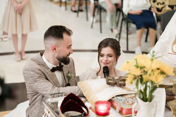 A heartwarming wedding ceremony captured, showing a bride and groom expressing their vows. The image radiates love and commitment, a tender moment in their special day.