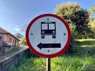 Placa de sinalização com sentido de carro na cor vermelha.