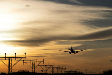 Plane landing, backlit in the sky at a beautiful sunset. A large, beautiful plane. You can see the...