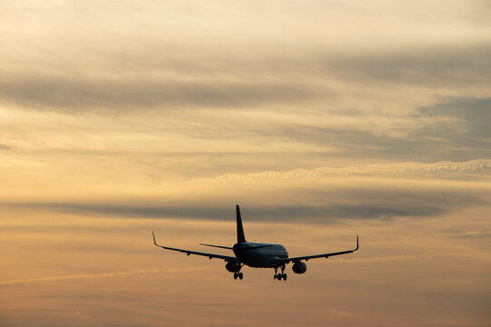 Plane landing, backlit in the sky at a beautiful sunset. A large, beautiful plane. A beautiful image of the sky and the plane landing.