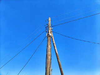 Old pole with wires against the sky. Electric transmission line. Eco-friendly energy