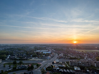 Obraz premium A breathtakingly beautiful sunset is casting warm hues over a serene and picturesque townscape under a dramatic sky