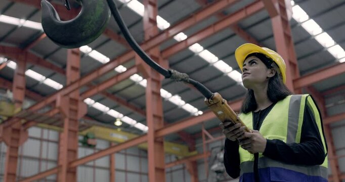 Asian female engineer using machine control tools factory. Modern factory control technology. Safety standards while working Wear helmet. woman workers working professional. Industrial industry