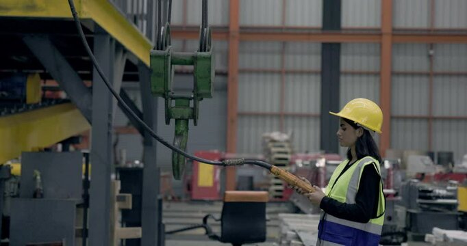 Asian female engineer using machine control tools factory. Modern factory control technology. Safety standards while working Wear helmet. woman workers working professional. Industrial industry