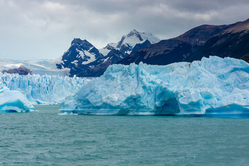Patagonia famous glacier Perito Moreno in Argentina. Blue ice blocks falling in the lake at the...