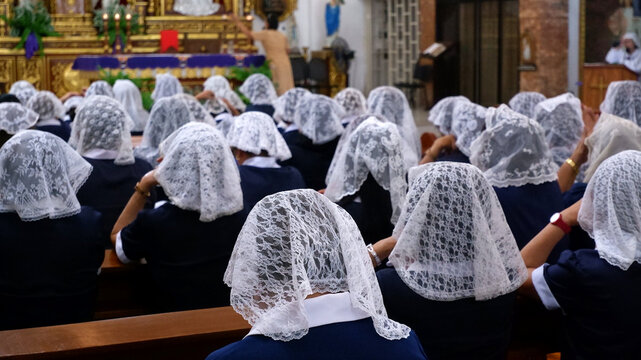 Members of the Catholic Women's League (CWL) in blue uniforms are attending a holy Mass before an oath-taking ceremony.