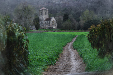 A path leading to a Priory in the countryside on a wet rainy day, Little Malvern Priory, UK, with a grunge vintage edit.