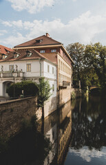 Fototapeta premium Canal between historic buildings with reflections and blue sky