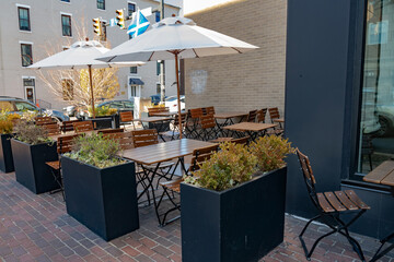 cozy outdoor street cafe. Empty Tables and chairs under umbrellas.