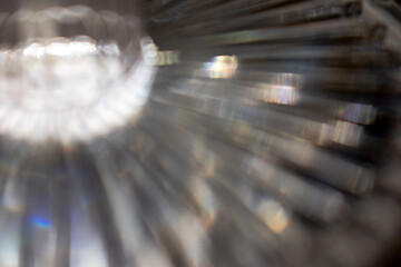 Abstract close-up featuring blurred radial patterns. The textureglossy, creating a visual rhythm of lines converging towards a bright focal point, lending a dynamic sense of depth and movement.