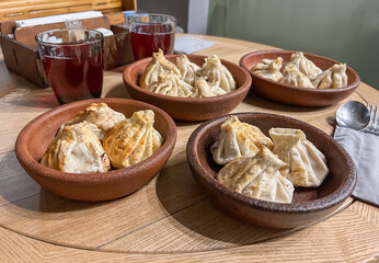 Traditional Fried Khinkali Dumplings Presented in Clay Bowls at a Restaurant.Delicious Georgian Food: Close View of Golden Fried Khinkali Ready to Eat