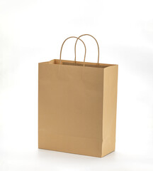 Brown paper shopping bag with sturdy handles stands against plain white background, showcasing its...