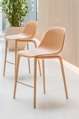 Two light beige plastic counter stools with slender legs, positioned in a modern minimalist interior