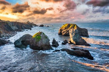 Dramatic coastal cliffs along California's Highway 1 in Northern California, bathed in golden...