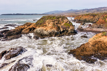 Fototapeta premium Stunning coastal landscape along California's Highway 1, featuring rugged rocky formations, and the vast blue ocean. A breathtaking natural scene showcasing the raw beauty of the Pacific coastline