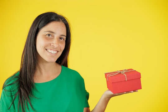 Smiling woman holding red gift box for shopping, celebration and special occasions