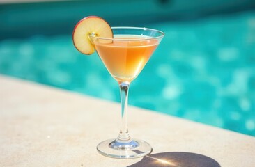 Refreshing peach cocktail by poolside on a sunny day