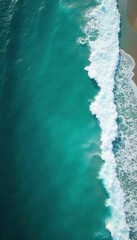 Aerial view of turquoise ocean waves crashing on shore, seascape, sunlight reflection