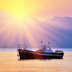 Old fishing boat against Crimea mountains at sunset