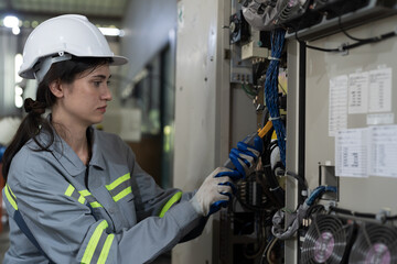 Female electrician worker checking, repair, maintenance operation electric system in the factory....