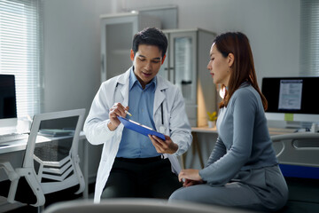 Doctor explaining diagnosis to patient while holding clipboard in hospital room, engaging in a supportive and informative consultation