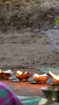Panning shot of burning earthen lamp or saki and incense sticks with assamese sarai vertical video