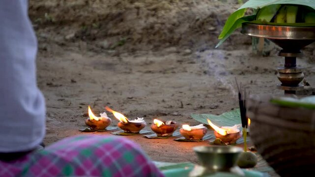 Composite shot of burning earthen lamp or saki and incense sticks with assamese sarai