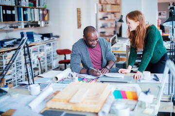 Young man and woman working together on a project in a startup company office