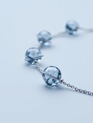 Closeup view of an ankle bracelet featuring crystal charms that resemble planets, beautifully showcased on a pure white background