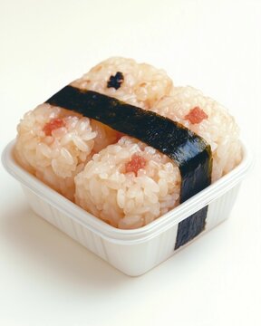 single triangular rice ball (onigiri) with a strip of nori, placed off-center on smooth gh and negative space, soft ambient lighting
