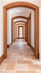 Long hallway with arched doorways, wood trim, and light beige tile flooring