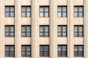 Fototapeta premium Building Facade: Symmetry and Shadows. Repeated window patterns create a compelling architectural design. Symmetry is beautiful and simple.