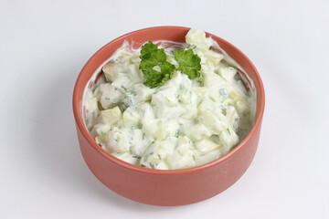 A healthy bowl filled with a fresh salad of cucumber, cottage cheese, and herbs, perfect for a light meal