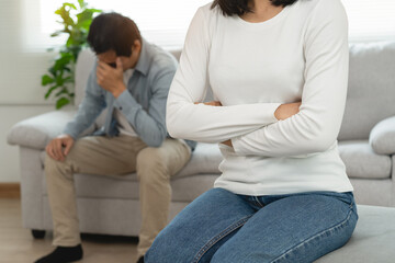 Family divorce problem concept, Husband and wife sitting separating after arguing in the living room at home.