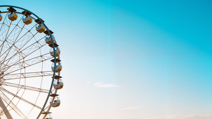 Fototapeta premium Ferris Wheel Silhouette Against Blue Sky - Vibrant Carnival Ride with Colorful Lights for Festival Season, Music Events, and Coachella-Inspired Content