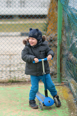 little boy riding scooter and laughing