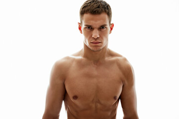 Fototapeta premium A focused young man with a muscular build, shirtless against a seamless white background. The lighting accentuates his features and defines his physique, conveying strength, focus, and determination.