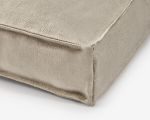 Corner of beige linen cushion showing stitching detail
