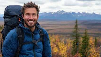 Naklejka premium Happy man hiking in the mountains with a backpack